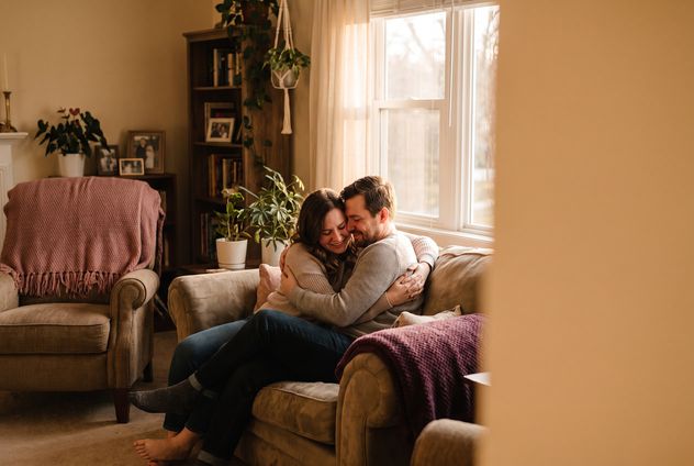 A person sincerely making up with their wife at home, a warm quiet moment of reconciliation and a hug