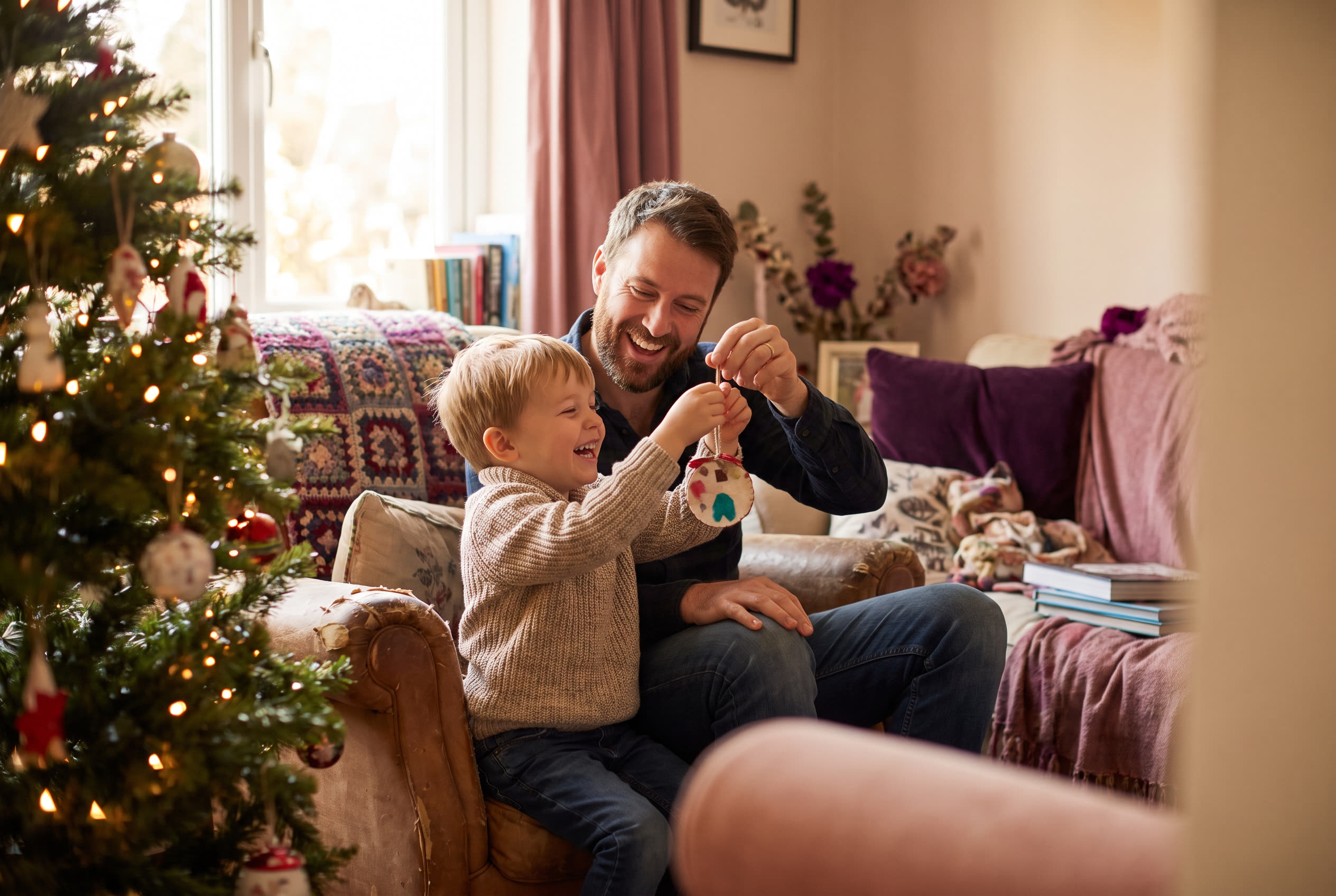 A person and their son sharing a joyful christmas moment at home